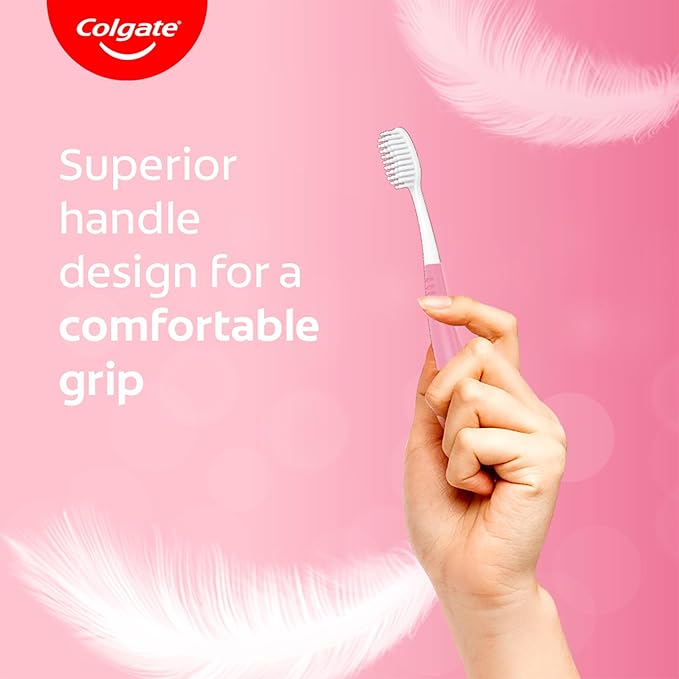 Hand holding a Colgate toothbrush with text on a pink background